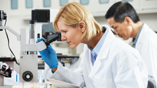 woman looking into microscope