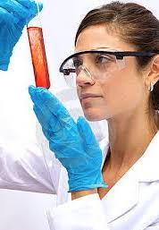 woman in protective eyerwear looking at test tube